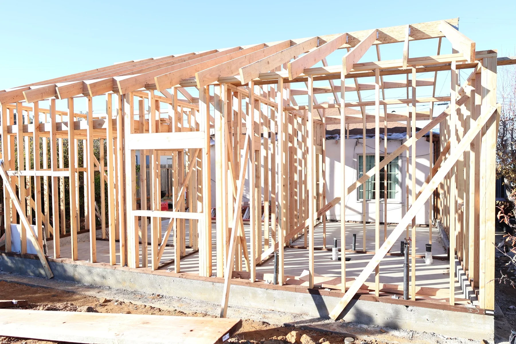 House addition with timber wall framing and roof trusses.