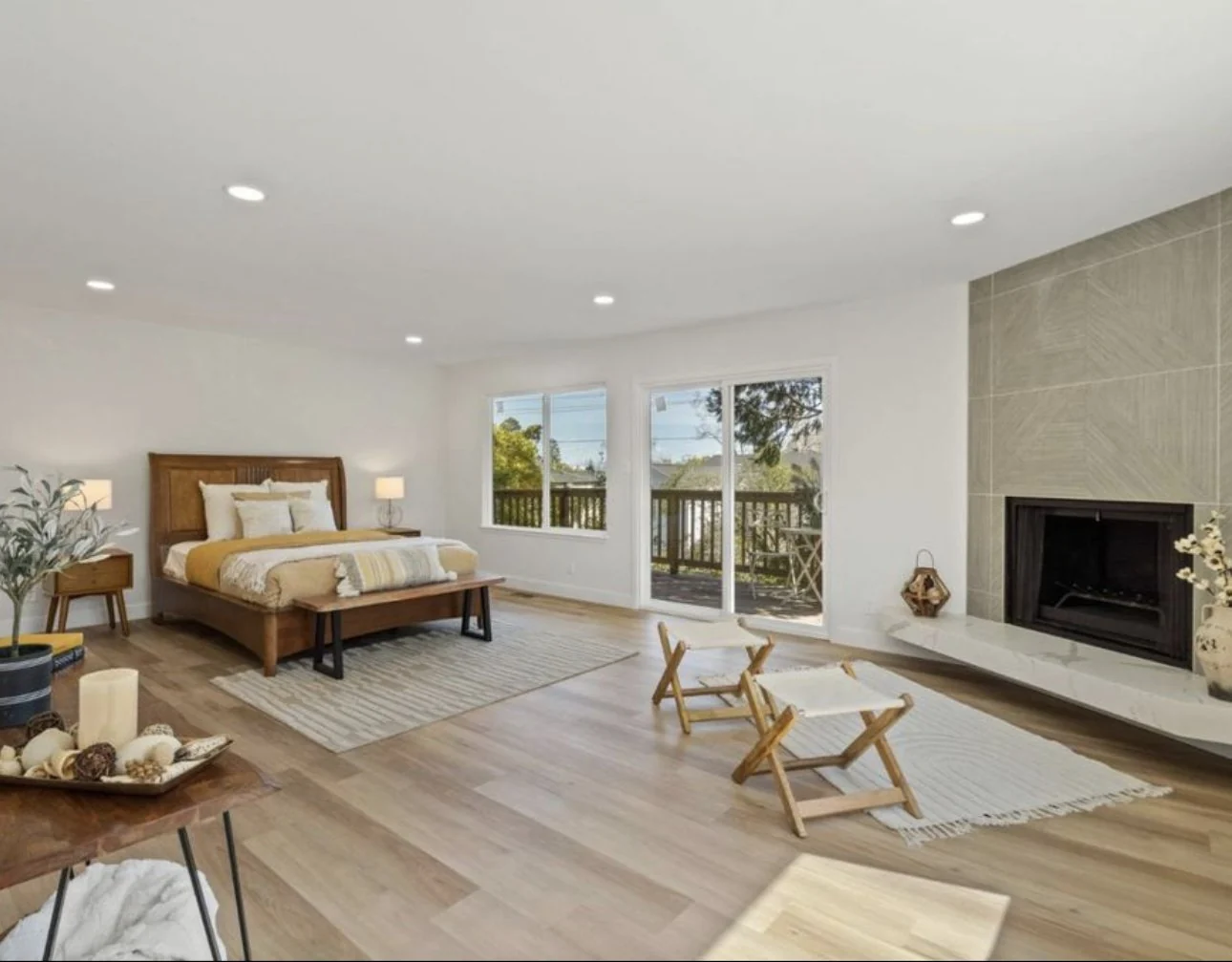 Bright bedroom with garden-facing doors and a fireplace.