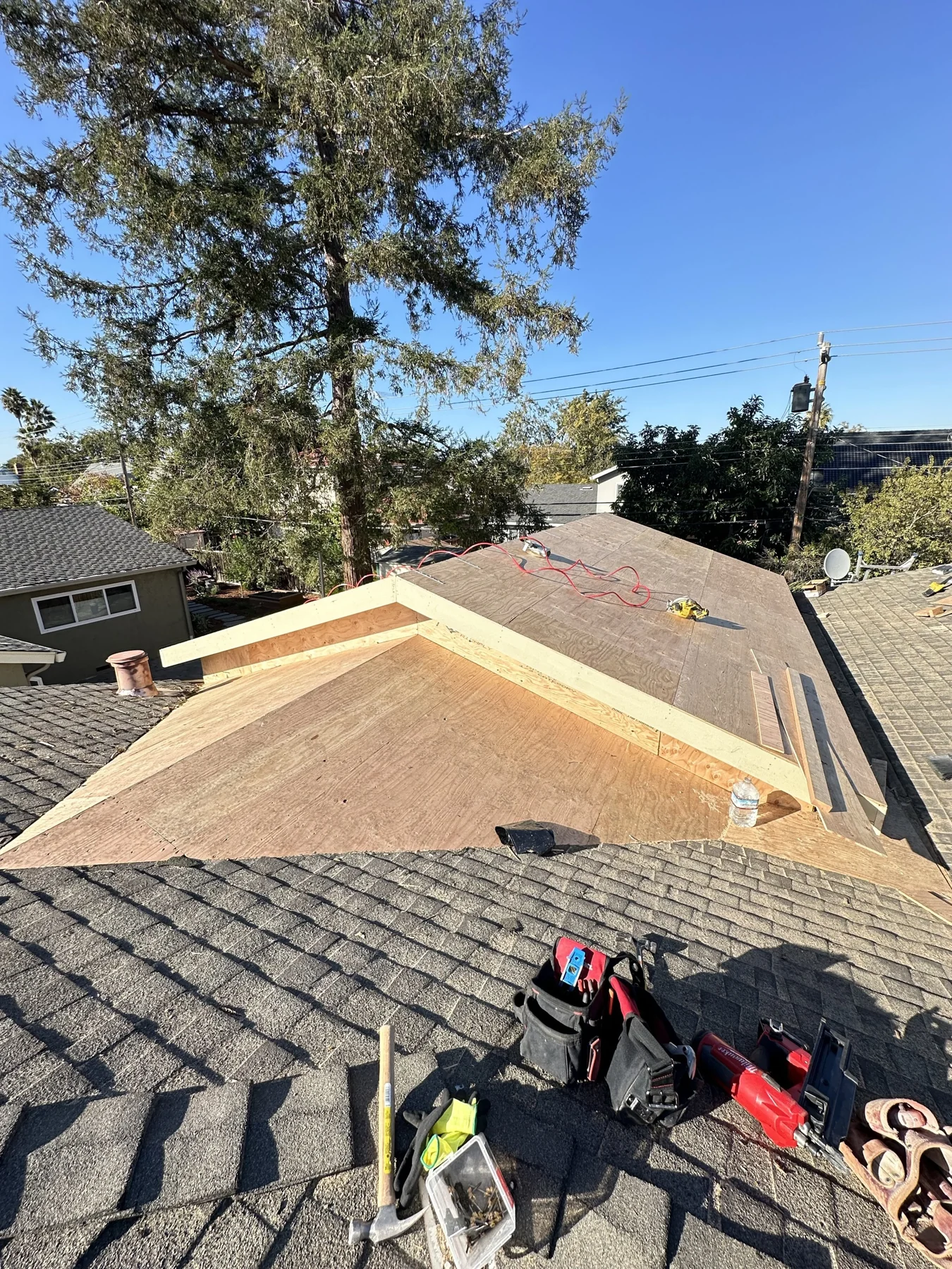 View over an existing roof toward new addition roof framing.