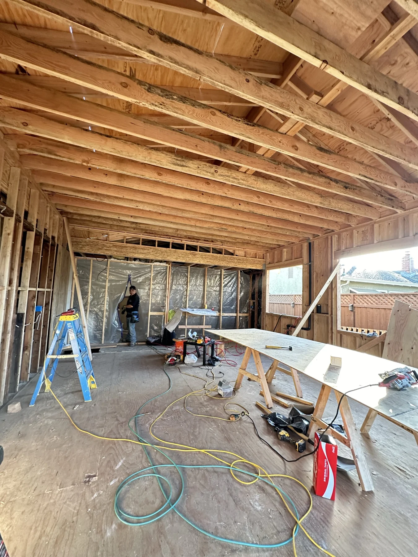 House addition interior under construction with exposed timber framing.