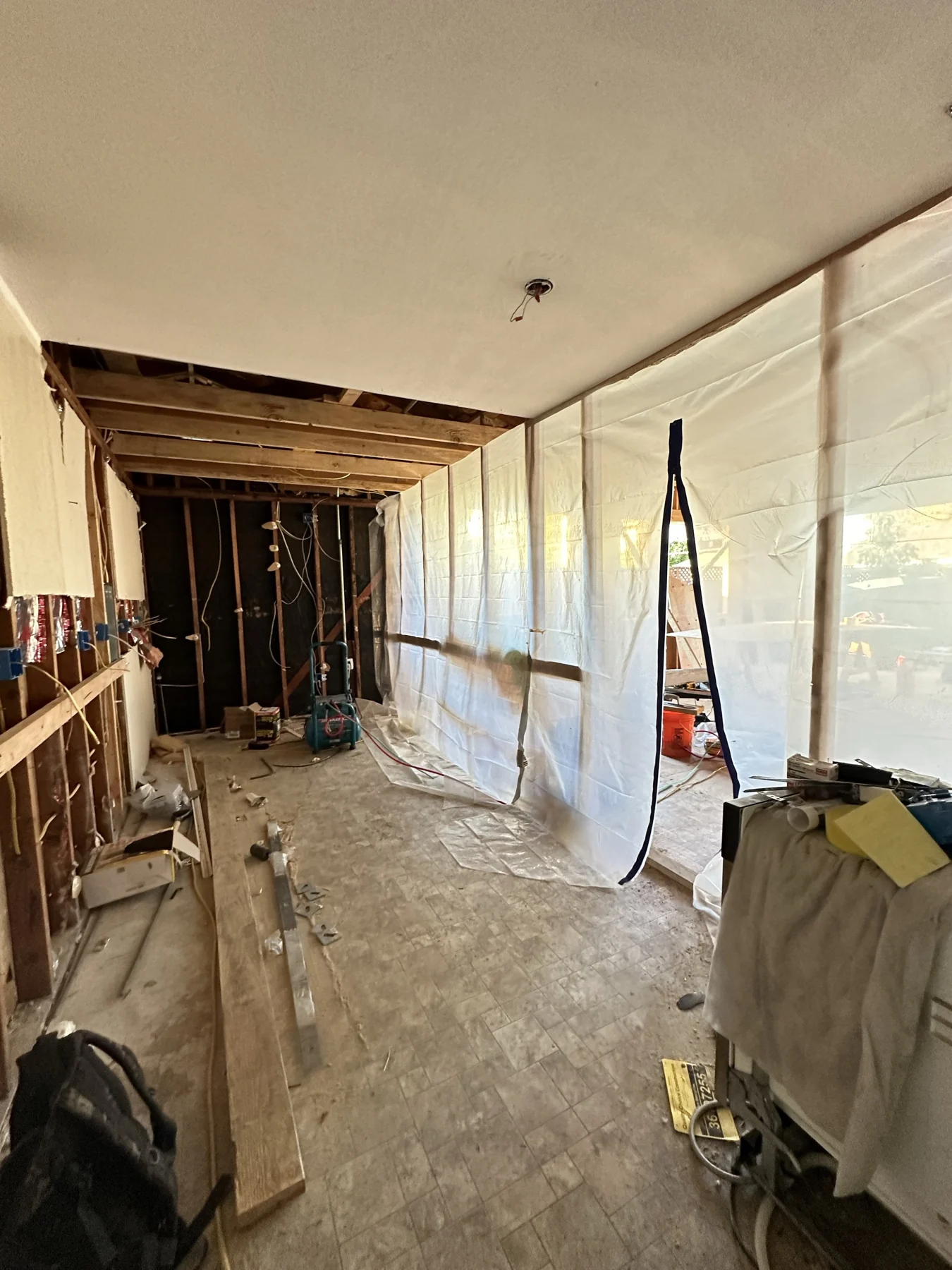 House addition corridor under construction with exposed framing.