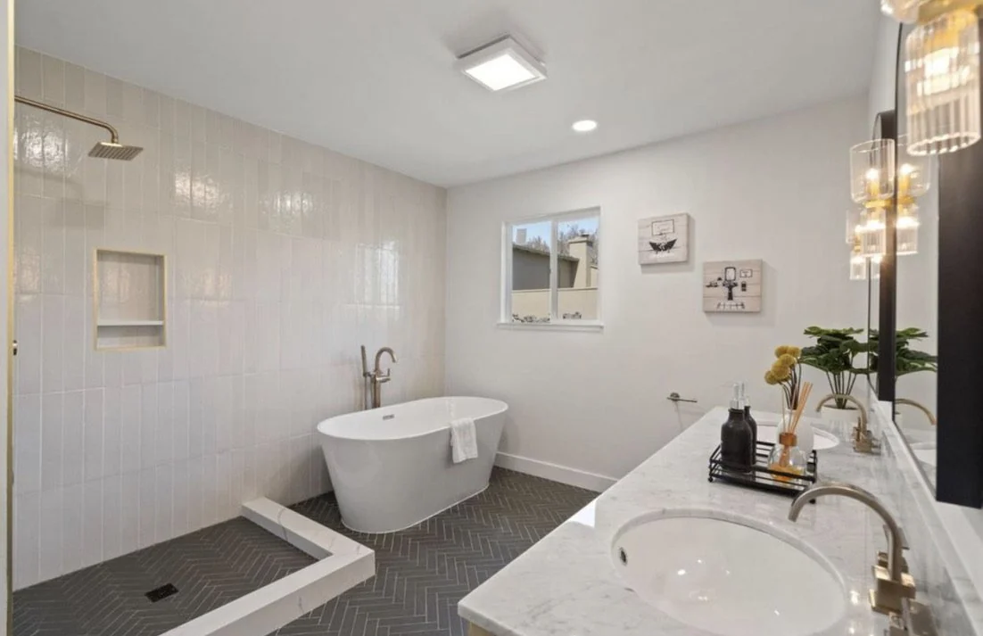 Bathroom with a freestanding tub, double vanity and tiled walk-in shower.