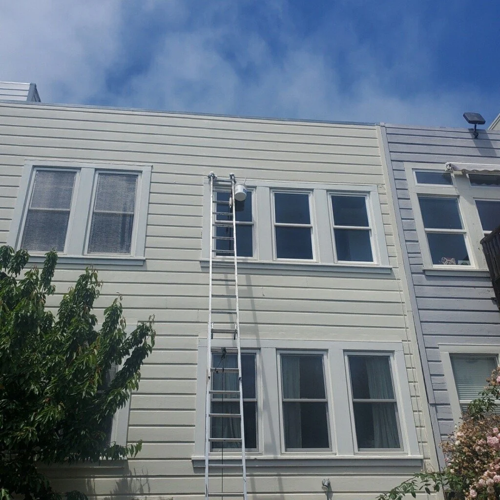 Light-colored painted multistory facade with white-trimmed windows.