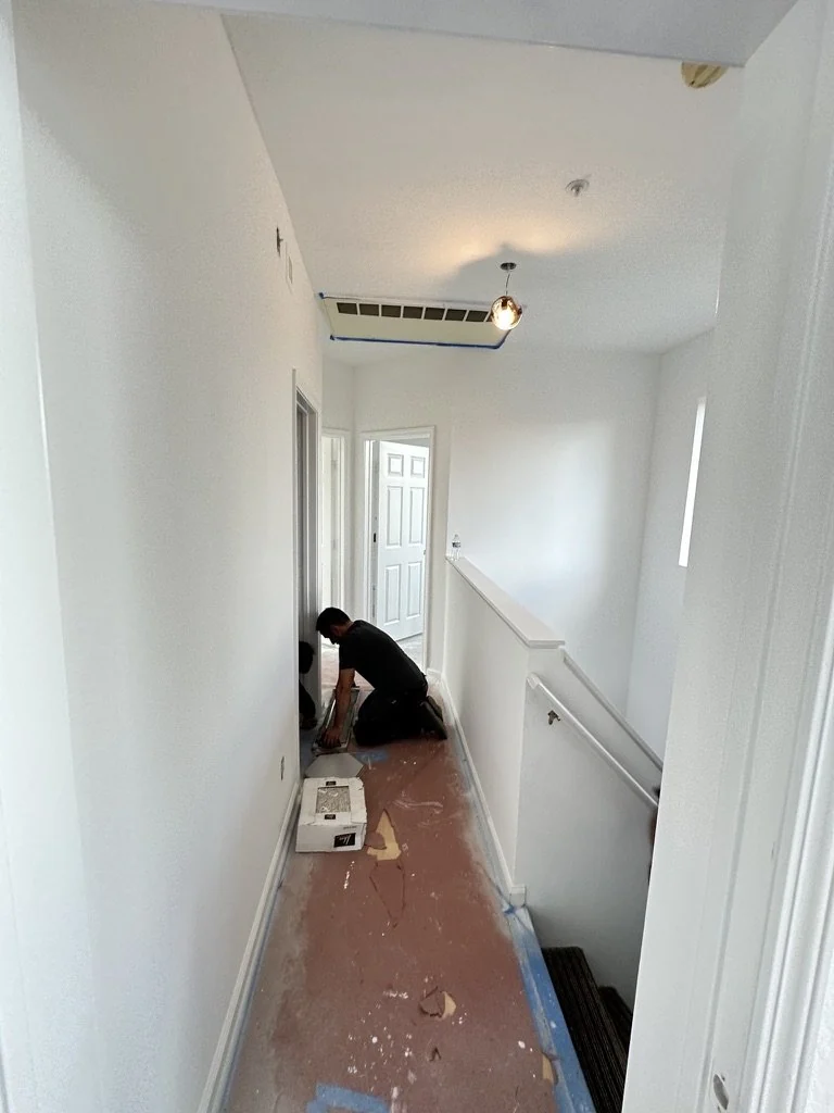 Interior hallway with fresh white walls and ceiling work in progress.
